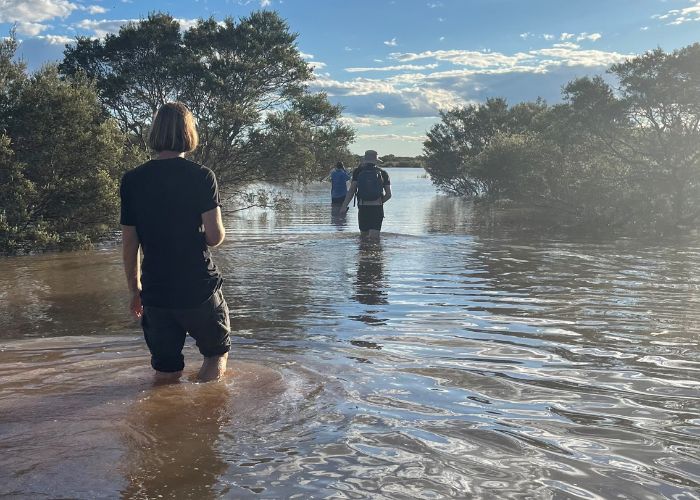 Ecologists walk through a water-filled lake after the rain at Newhaven Wildlife Sanctuary. 